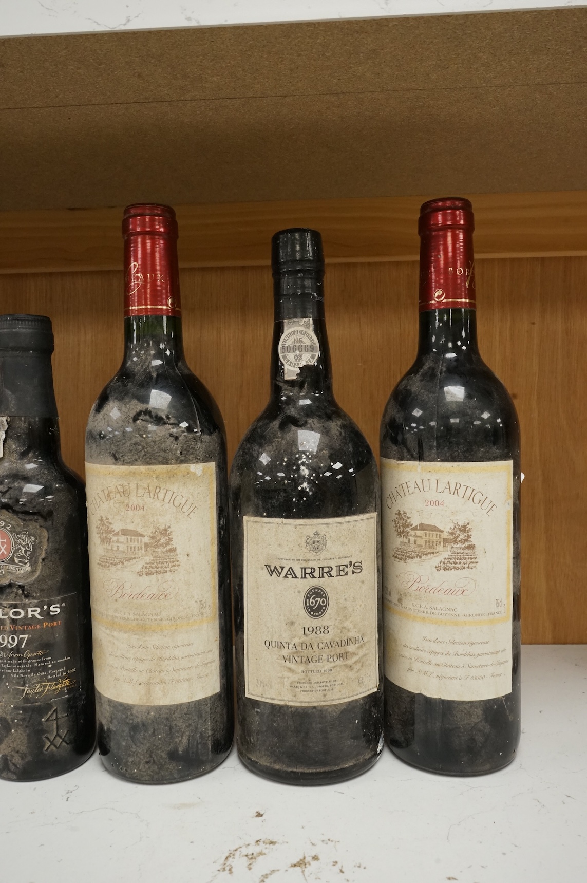 Two bottles of Warres 1988 vintage Port, a half bottle of Taylor's 1997, a Taylor's 10 year old Port, and two bottles of Chateau Lartigue, 2004